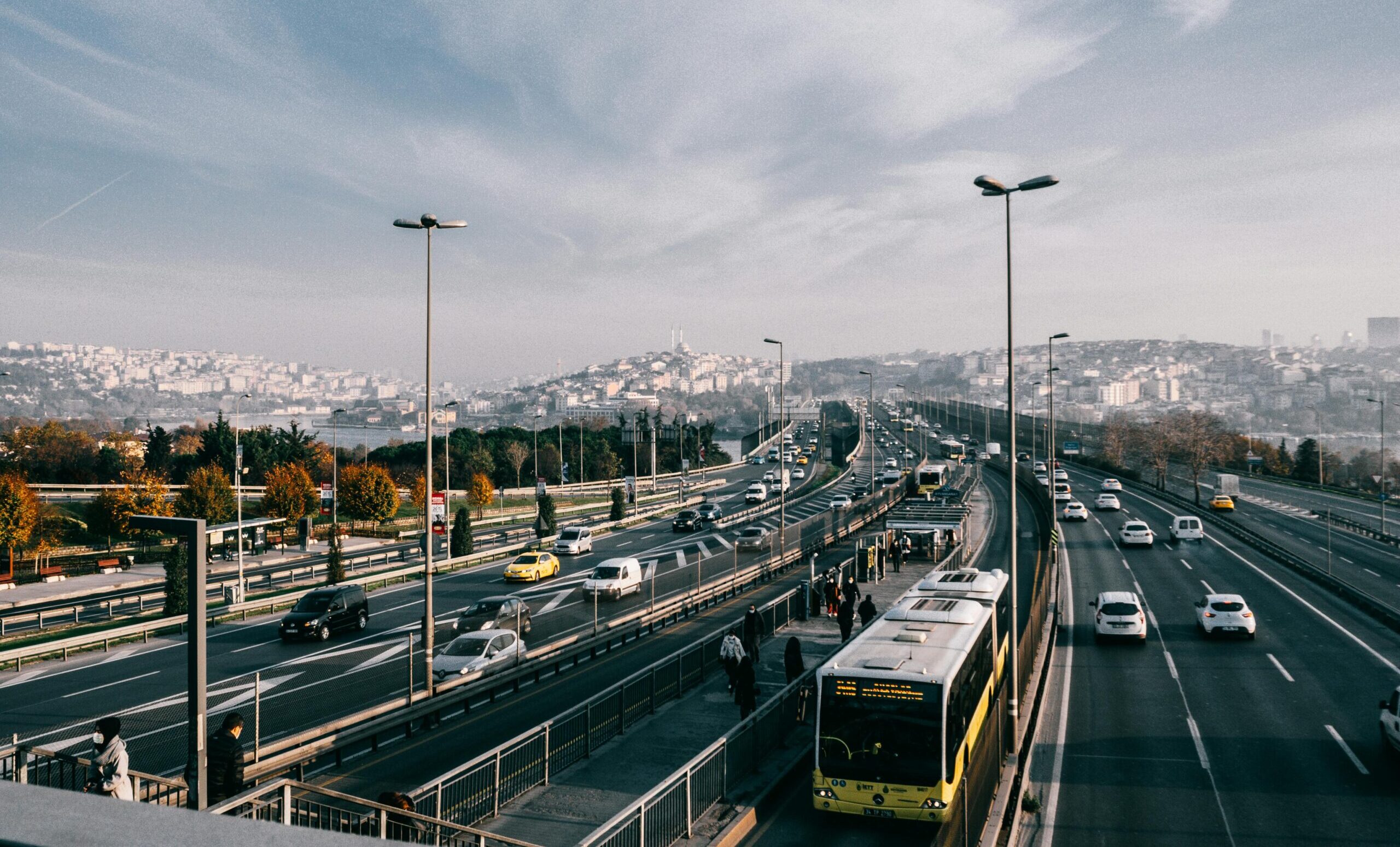 Dynamic view of Istanbul's Bosphorus Bridge with vehicles and commuters in autumn.
